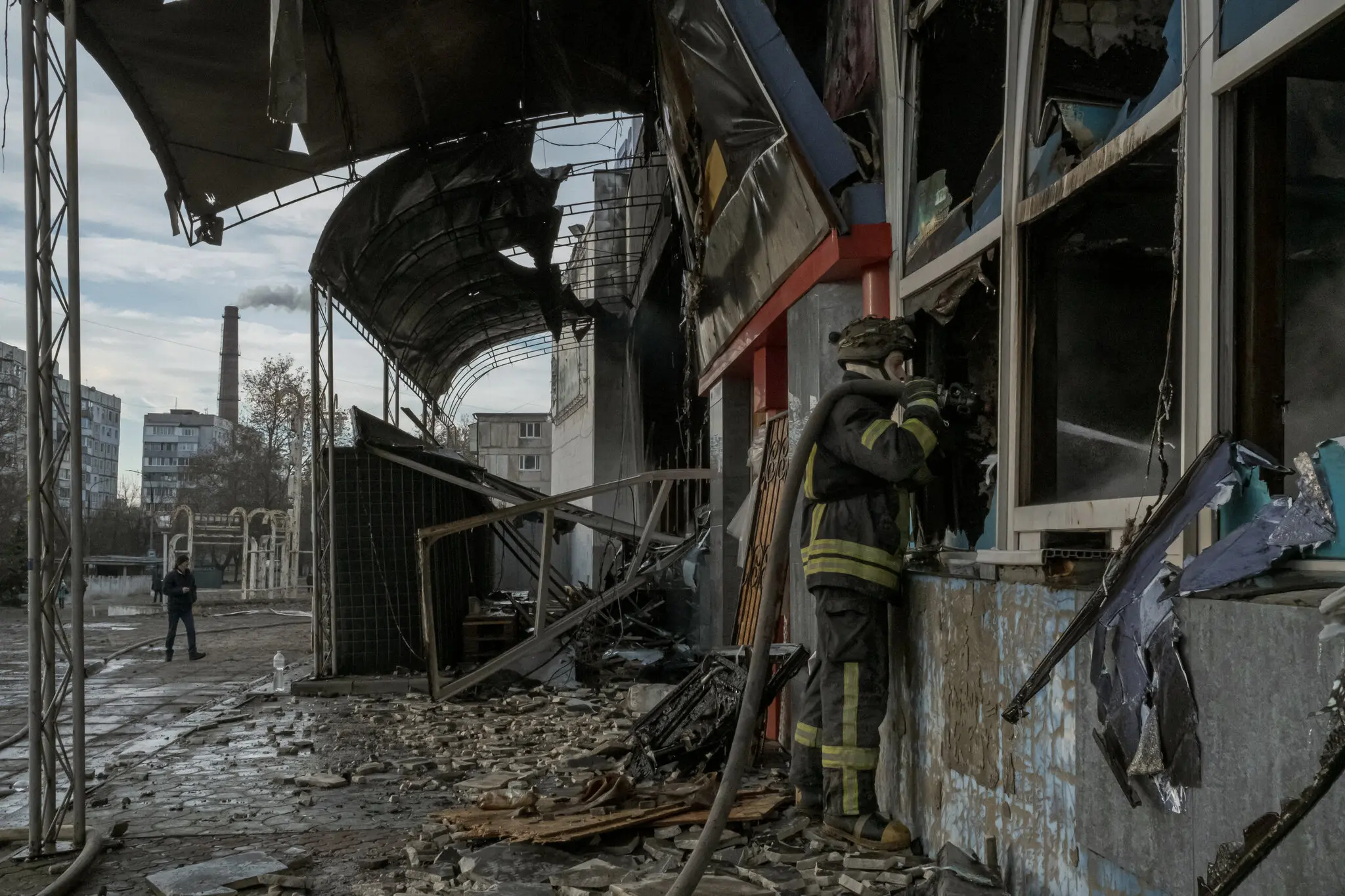 Пожежний гасить полум'я в кінотеатрі, де надають допомогу мирним жителям, які , за словами очевидців, постраждали від ракетного удару в Херсоні, 5 грудня.
